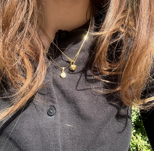 kani necklace and heart of gold necklace in gold worn in sunshine on girl