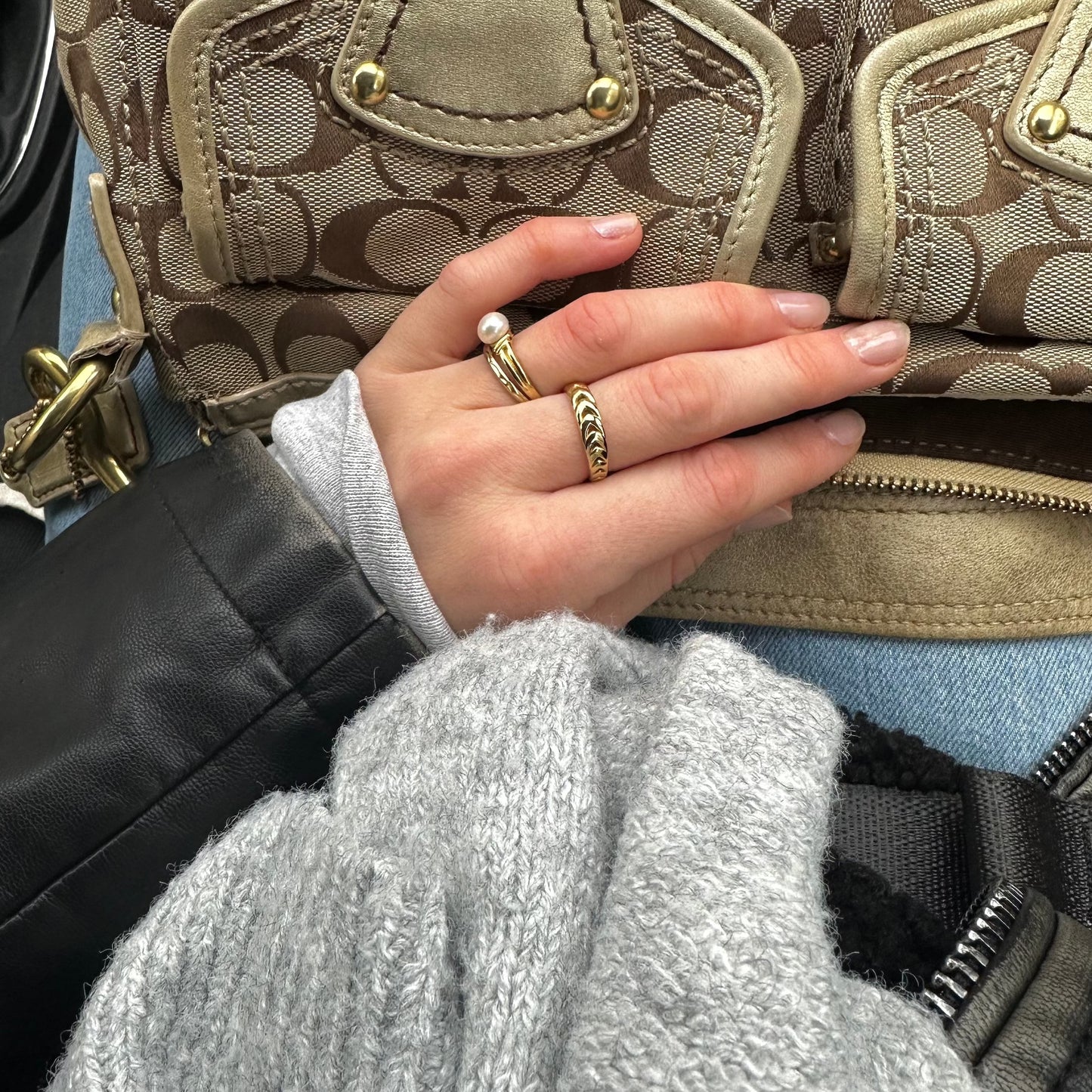 ring aus Gold an einer Hand von einem Mädchen auf Tasche