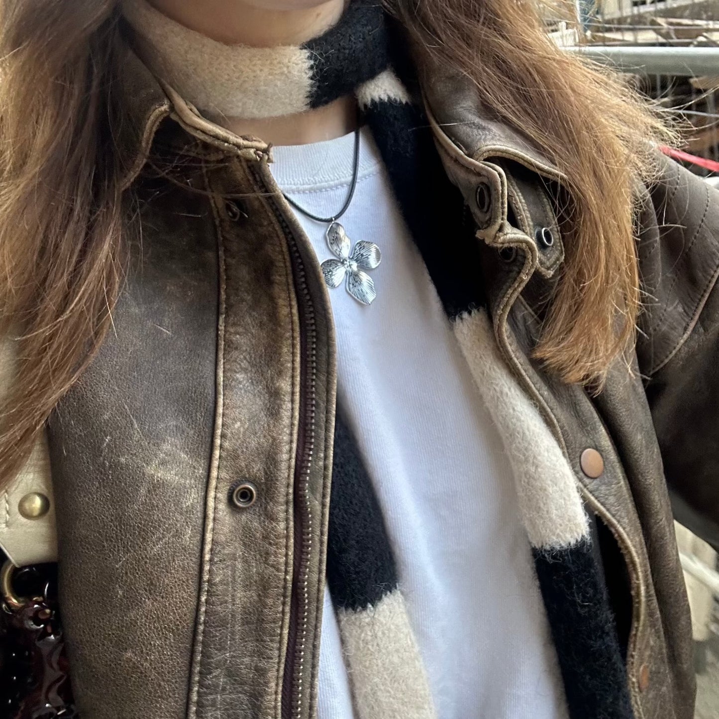 Silberling Halskette getragen an einem Mädchen mit Lederjacke