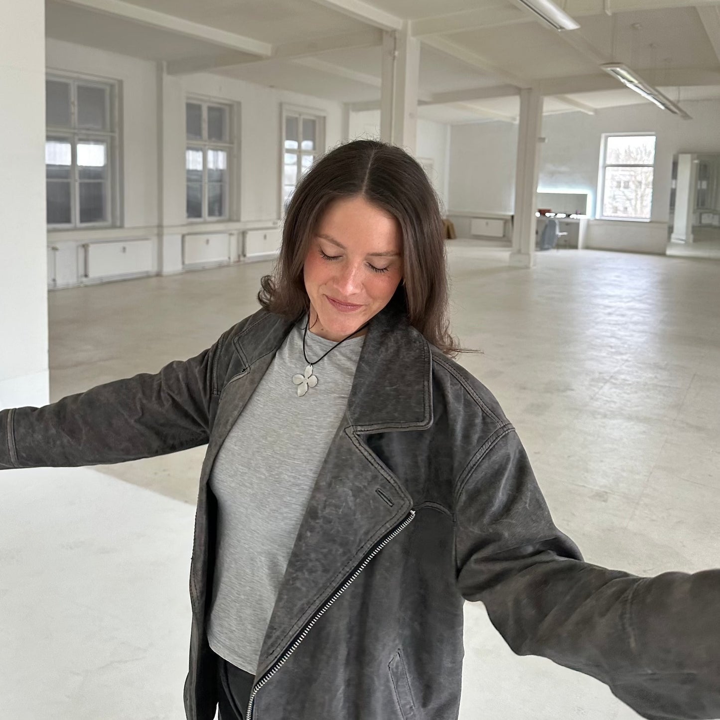 Silberling Halskette von einem Mädchen mit Lederjacke im Raum