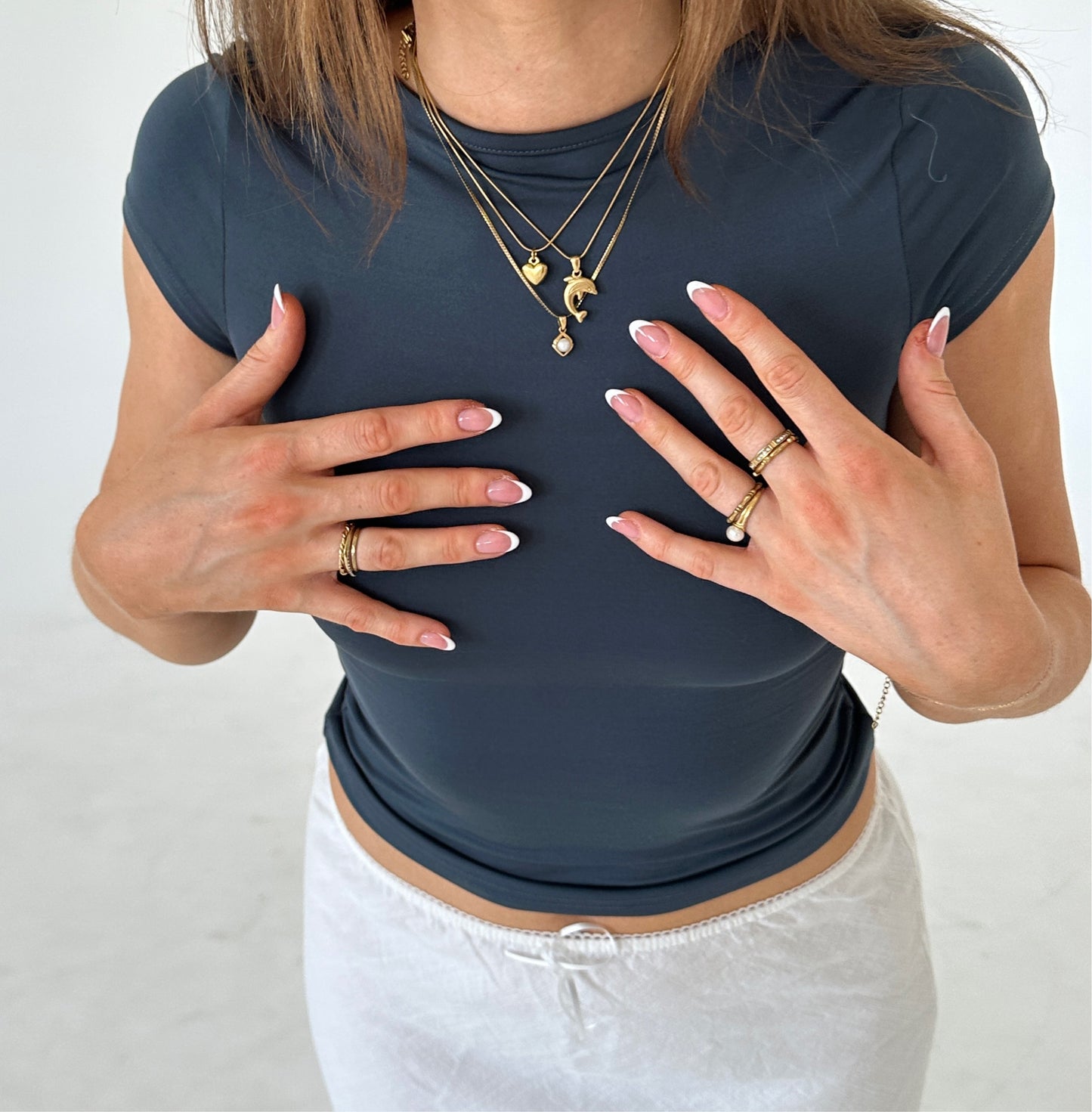 ringe in Gold und Halsketten Gold vor Mädchen mit blauem T-Shirt