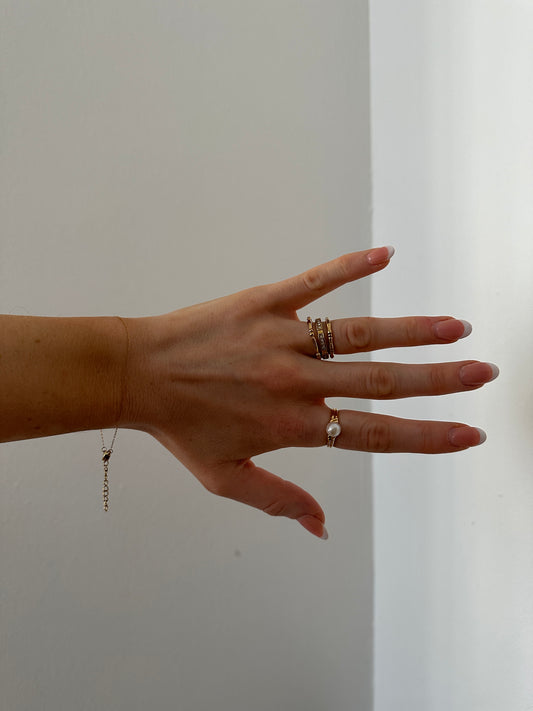 winzige Herzring anhand vor weißer Wand