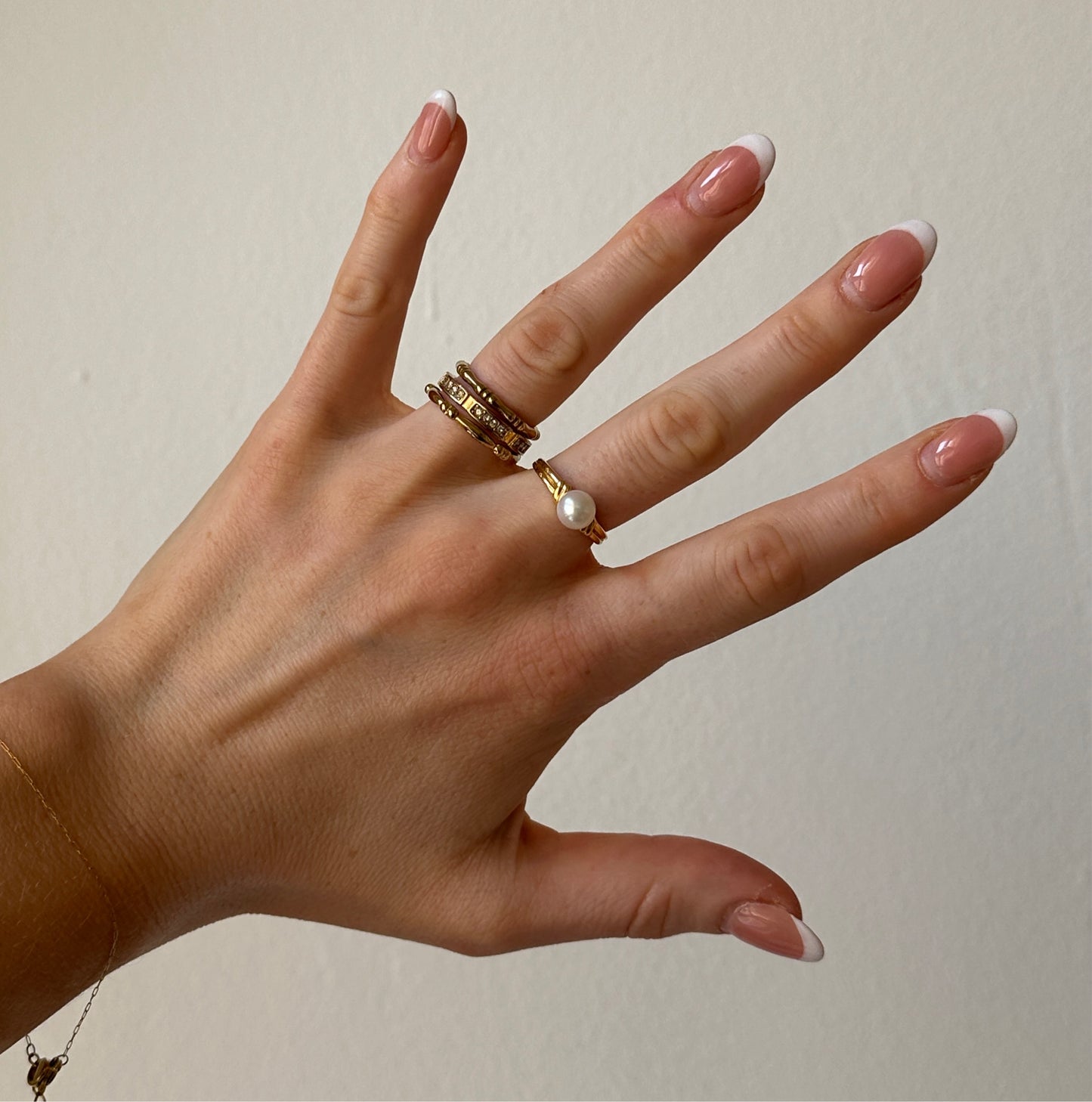 ringe an einer Hand vor weißer Wand