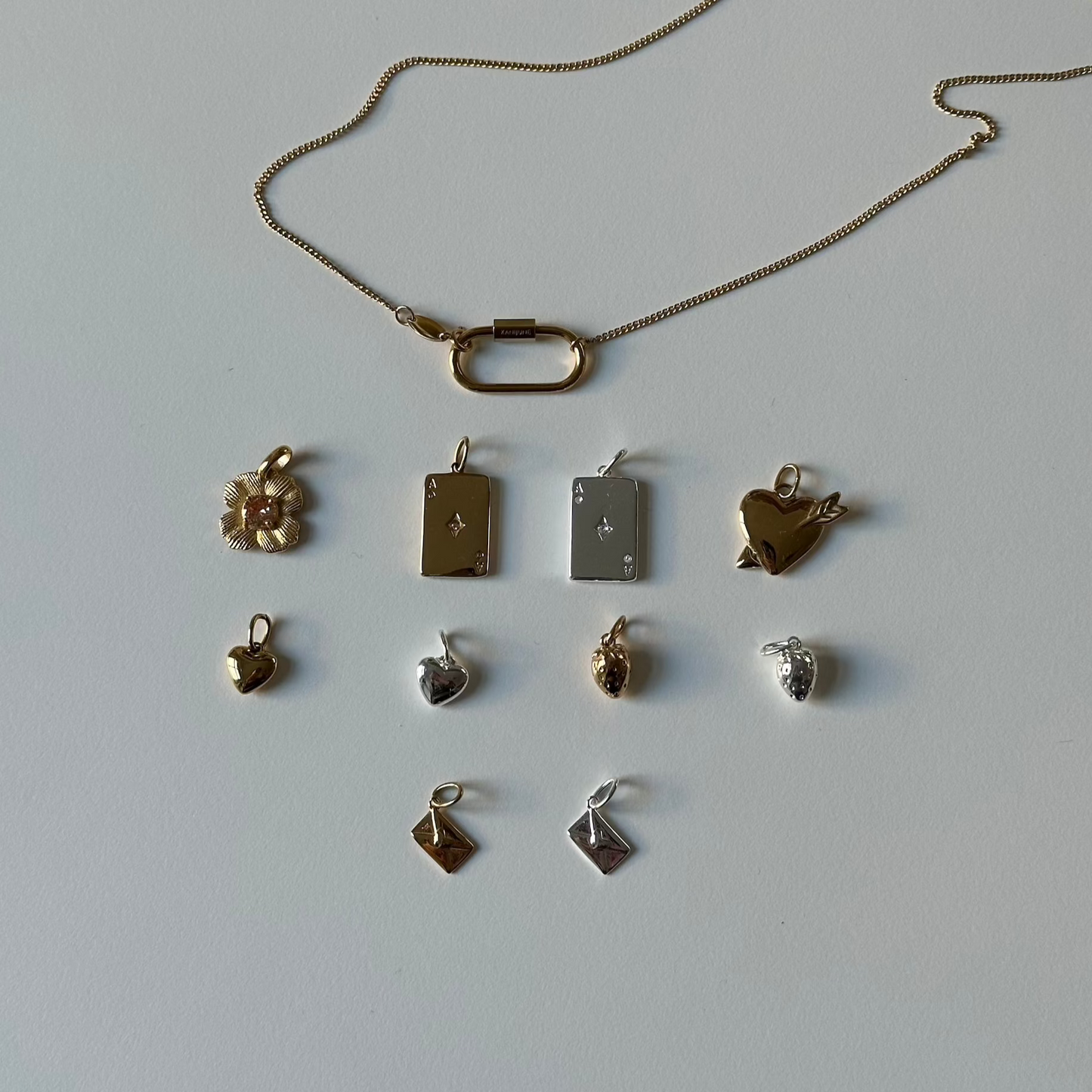 Mix and Match Halskette mit Charms in Reihen auf weißem Hintergrund