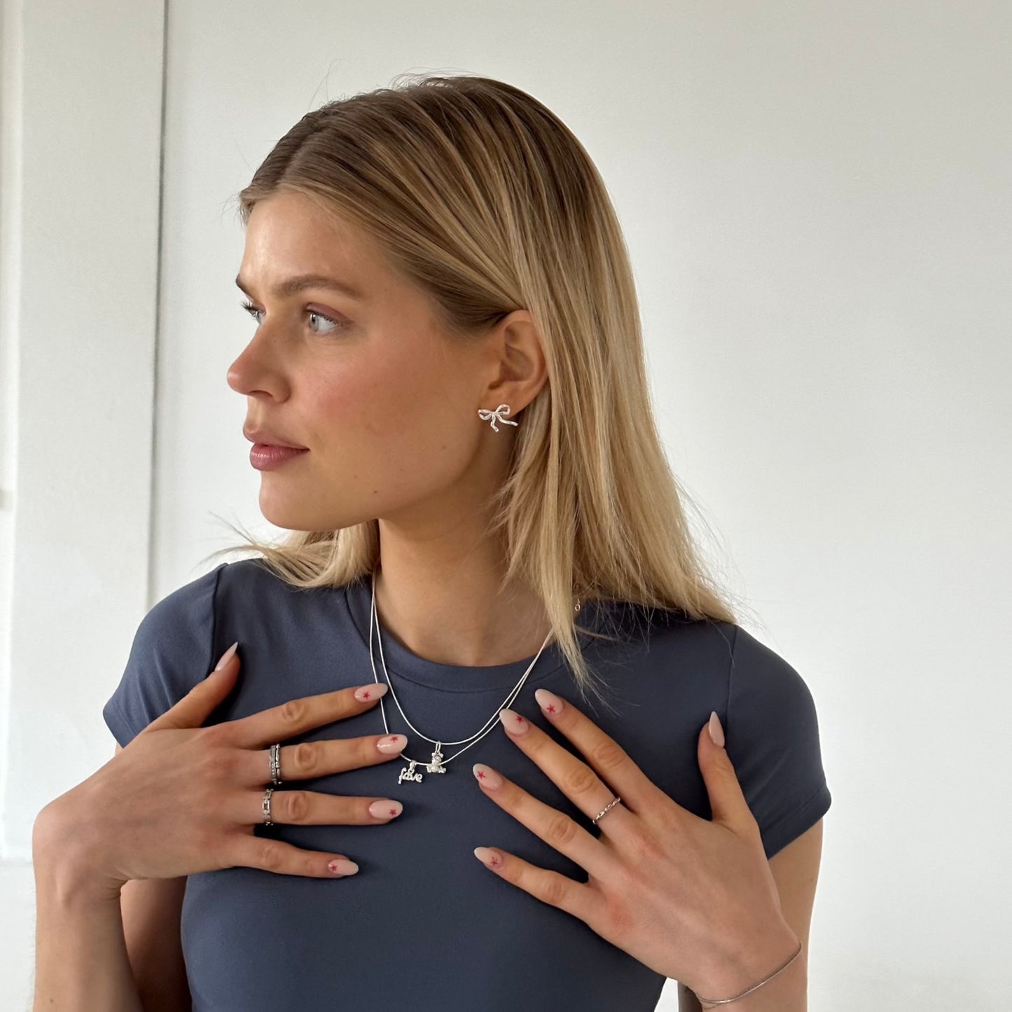 Ohrringe Bandnieten und Halsketten Silber getragen von blondem Mädchen