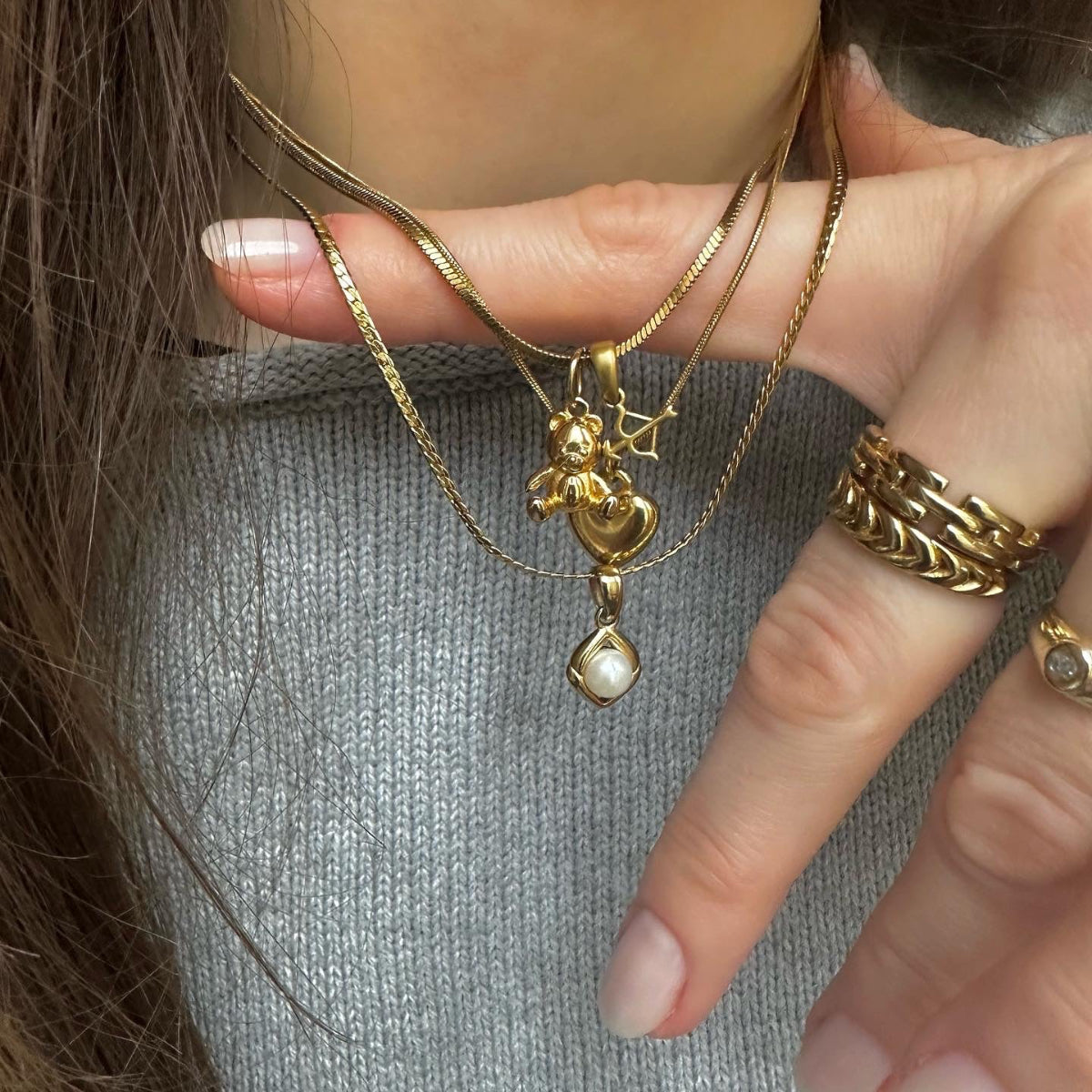 teddy necklace with bow and arrow charm and other necklaces worn