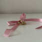 zwei goldene Ringe an einer Rosa Schleife