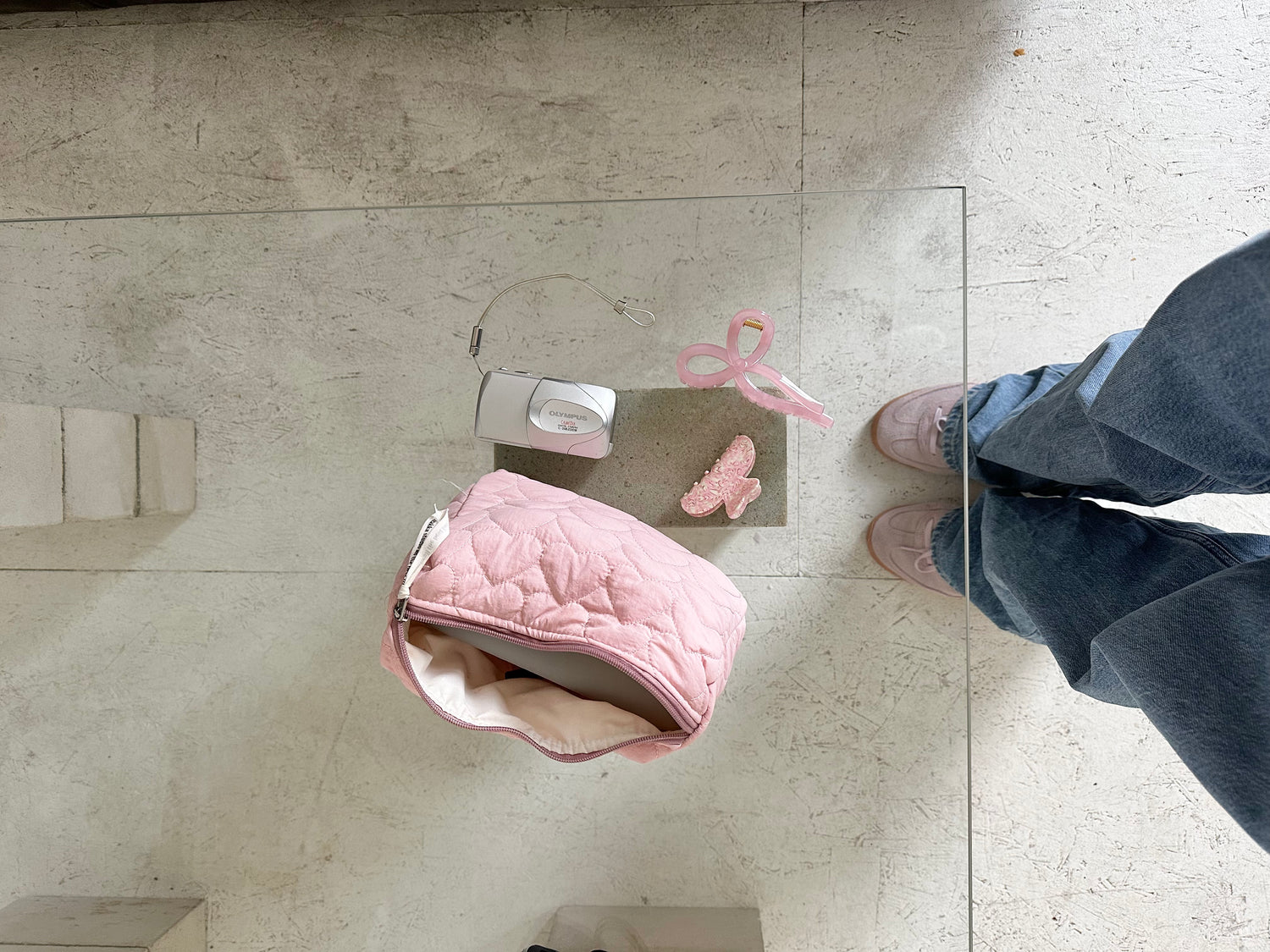 rosane Tasche und Accessoires von oben auf Glastisch