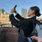 Mädchen, das Bella-Reifen in Gold auf den Straßen von Berlin trägt und ein Selfie macht
