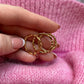 winziger Herzring in Hand vor Pullover