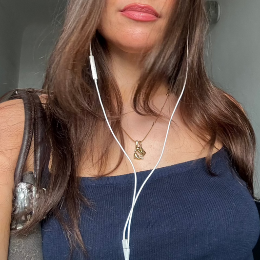 mirror photo seeing the phone holding and wearing gold jewelry and necklace 