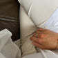 ringe an einer Hand vor weißer Hose